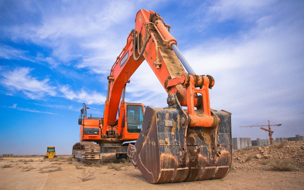Large commercial excavator on a construction site against a blue sky.